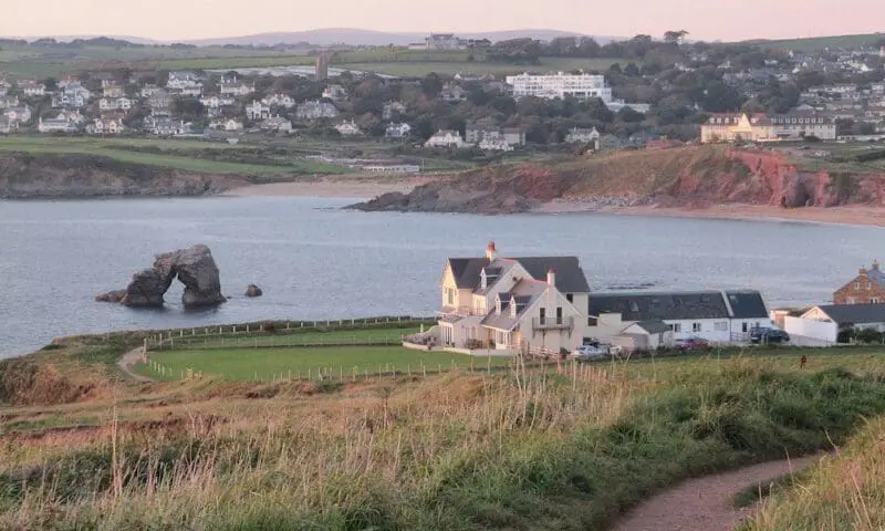 big rock in the water with a house