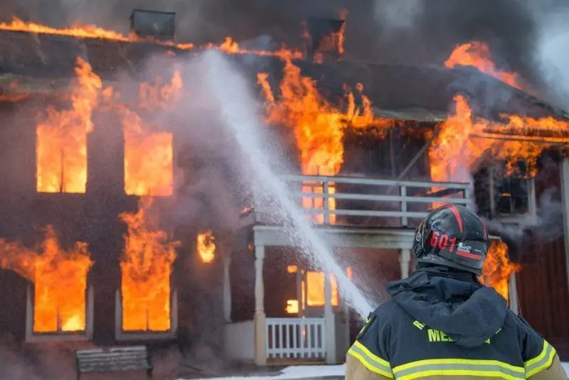 fire fighter putting out a house on fire