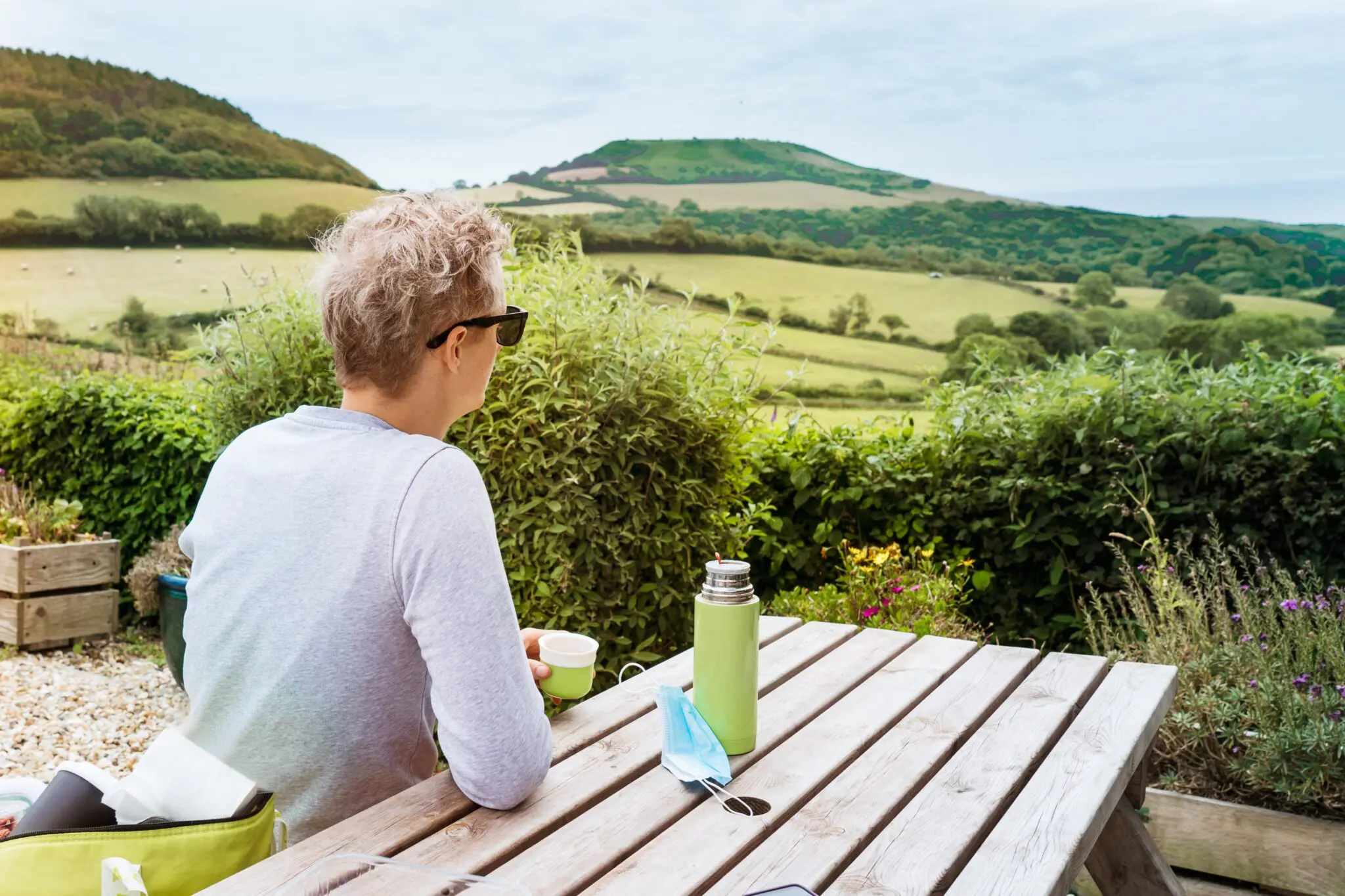Holiday home owner enjoying morning tea with Devon countryside views