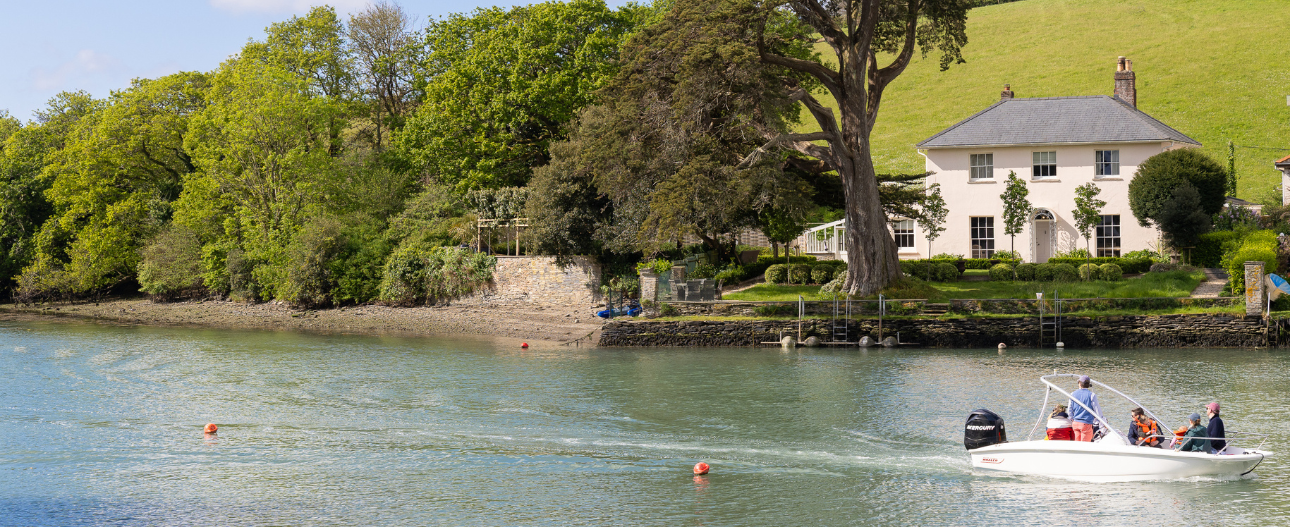 Waterside holiday home overlooking an estuary with a small boat passing