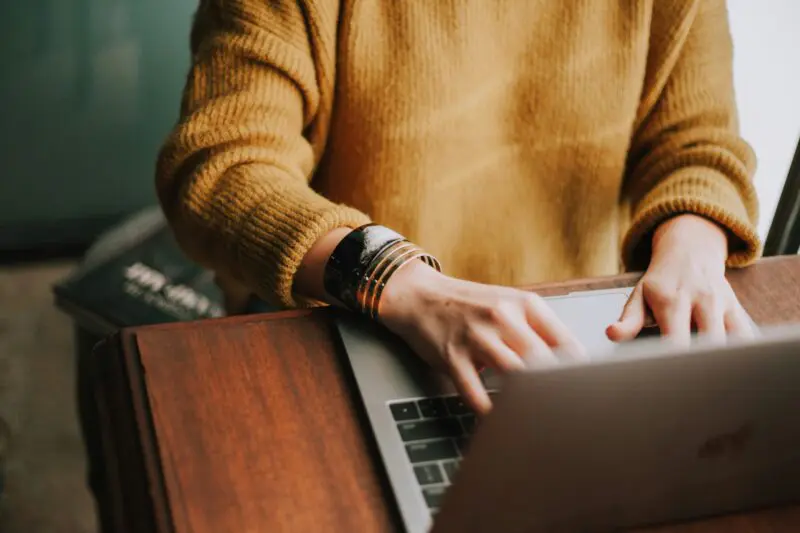 Holiday home owner reviewing her Airbnb listing and guest reviews on a laptop