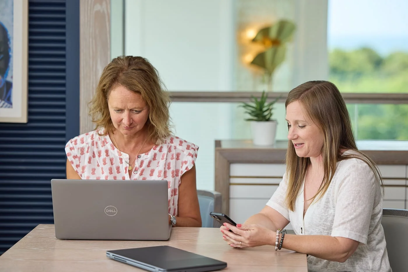 Two members of the HolidayHost team going through booking figures together on a laptop.