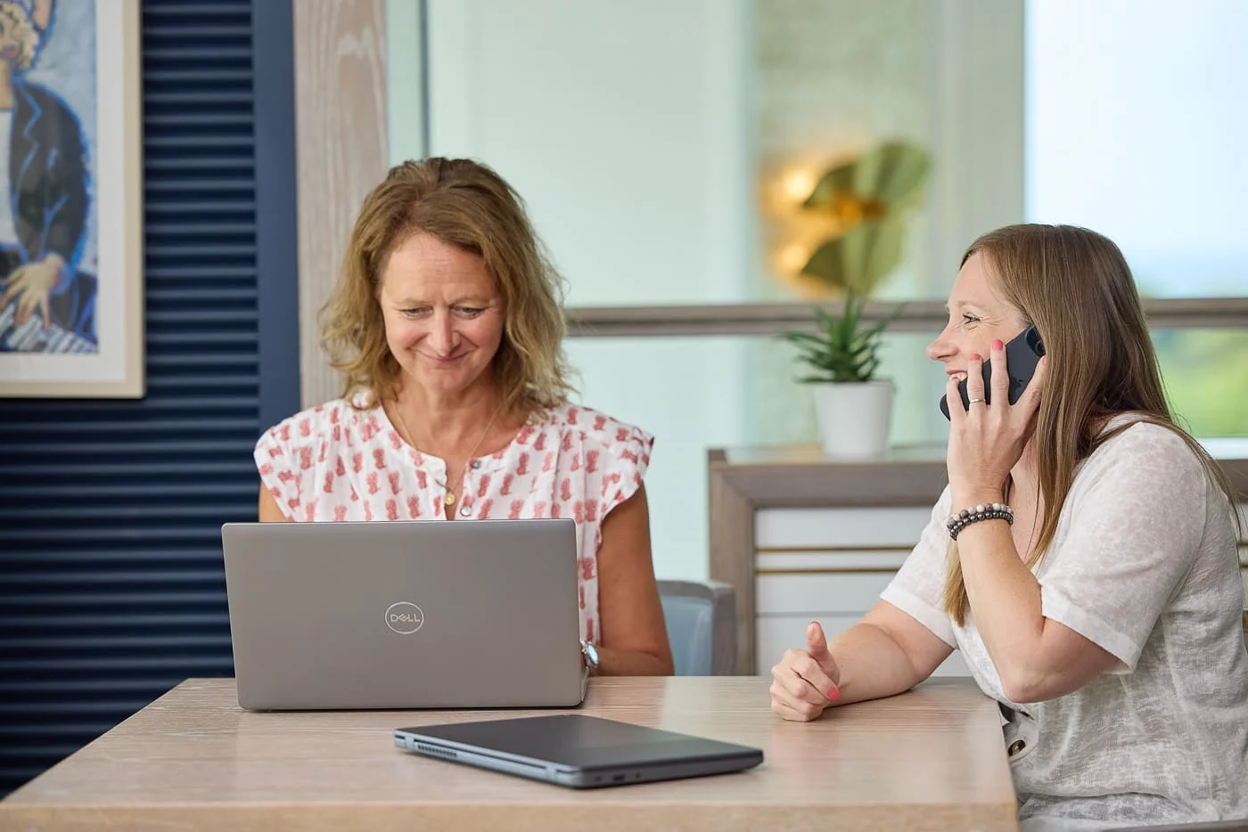 A HolidayHost team member working on a listing while a colleague takes a call.